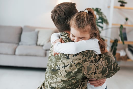 Finally meet each other. Soldier in uniform is at home with his little daughter photo