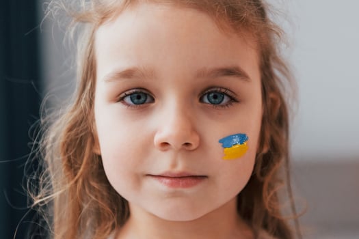 Close up view. Portrait of little girl with Ukrainian flag make up on the face photo