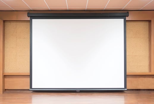 Front view of lecture room with empty white projector screen photo