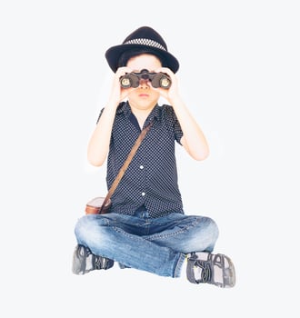 Vintage photo of 7 years old Asian traveler boy is sitting and using binoculars