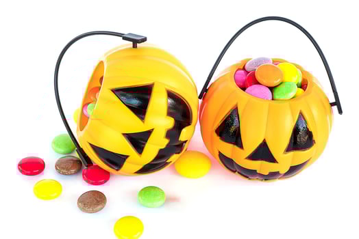 Halloween pumpkin face buckets with colorful candy inside isolated over white photo