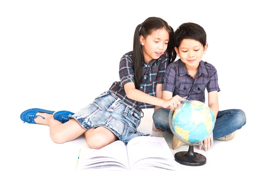 Asian 7 and 10 years boy and girl are studying world map, isolated over white background photo