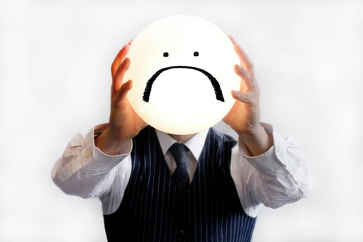 Businessman holding sad smiley face photo