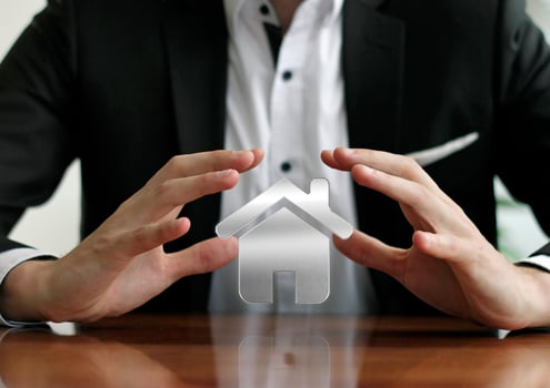Businessman protecting house with hands photo