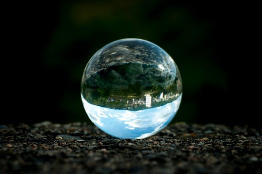 Dark blue image of a lens ball with inverted landscape view. photo