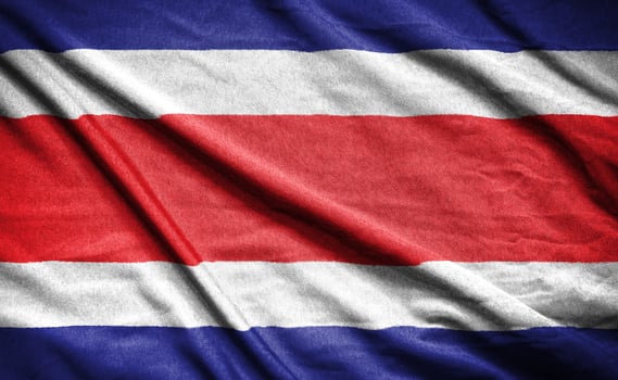 Realistic flag of costa rica on the wavy surface of fabric photo