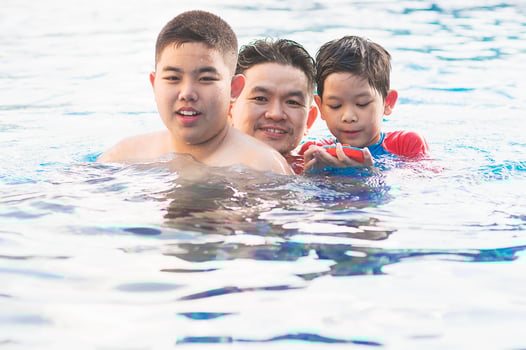 Happy dad and son swimming in a pool photo