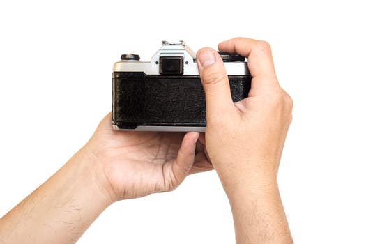 Man holding film camera ready to take photo over white background