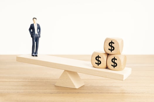 Life and Work or money balance concept. Businessman figurine and dollar symbol on wooden blocks on wooden seesaw photo