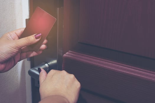 Vintage photo of lady using key card opening door in hotel room