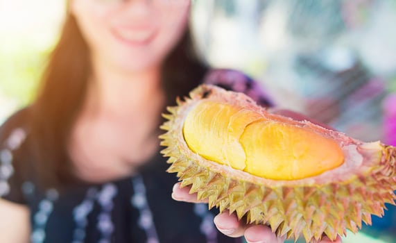 Close up of ready to eat durian fruit in lady hand photo