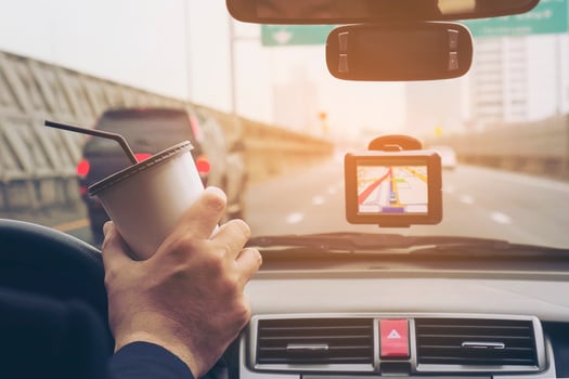 Man driving car using navigator and holding coffee cup photo