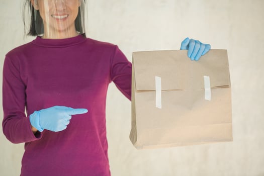 Close up cropped hands hold brown clear empty blank craft paper bag food for takeaway isolated on white background. packaging template mock up. delivery service concept. copy space. advertising area. photo
