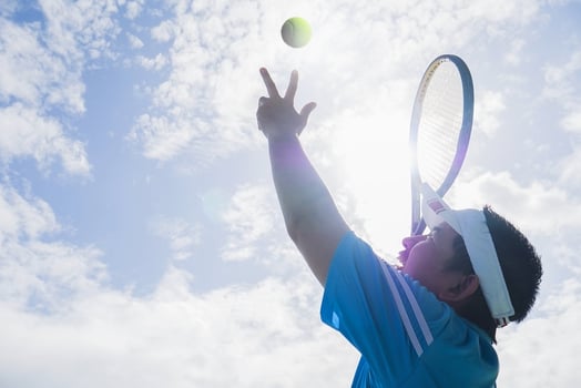 Tennis player is serving during a match photo
