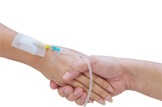 Man holding woman, patient, hand with a tube of medicine injection on a bed in a hospital.Photo includes clipping path. photo