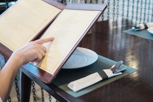 Woman is choosing food in a menu to order in restaurant photo
