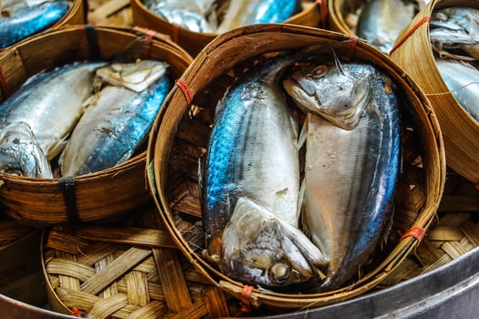 Close up The famouse Thai traditional Steamed mackerel fish in basket bamboo or wicker basket in thailand market. photo