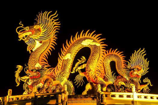 The Chinese style Golden statue of a magnificent golden king dragon with light up illuminated at night. photo