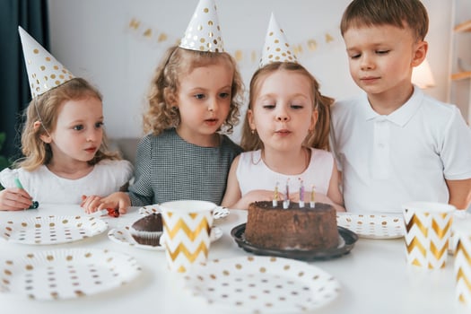 Sweet cake is on the table. Celebrating brithday. Group of children is together at home at daytime photo