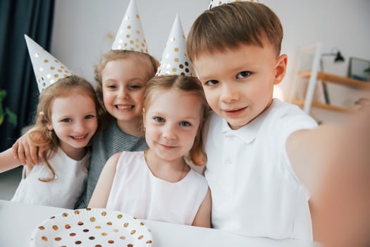 Making selfie. Celebrating brithday. Group of children is together at home at daytime photo