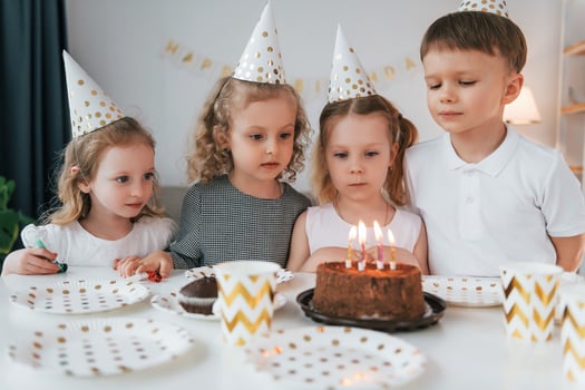 Sweet cake is on the table. Celebrating brithday. Group of children is together at home at daytime photo