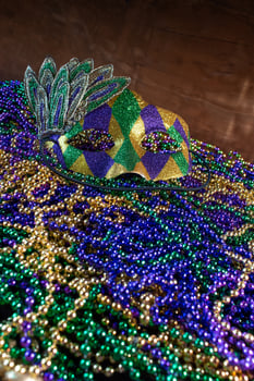 Pile of Mardi Gras beads with colorful carnival mask with copy space photo