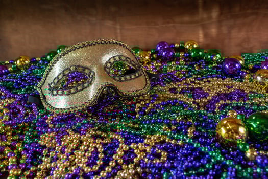 Pile of Mardi Gras beads with colorful carnival mask with copy space photo