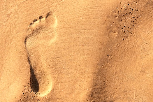 Footprint of a bare human foot in the sand photo