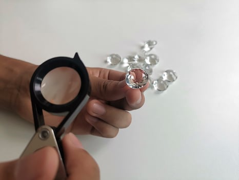 Gem stones. Jeweller checking polished diamond. Carat size diamonds. Diamond trading and dealing. Loose diamond grading. Precious stones photo