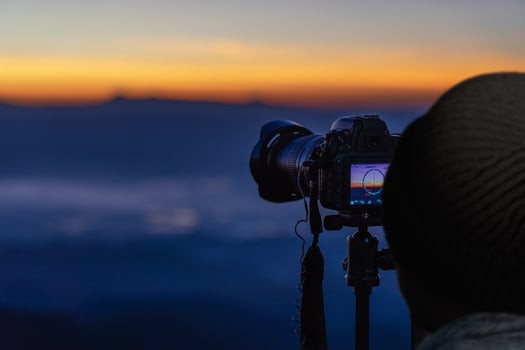 Traveler photographer taking pictures of mountain landscape at sunrise. photo