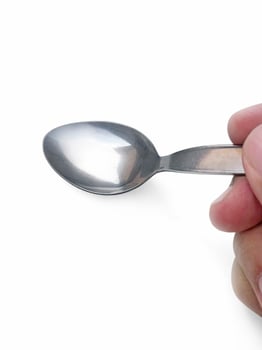 Spoon in hand on white background photo