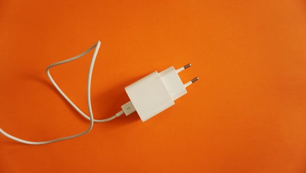 white voltage charger with usb cable for phone and gadgets charge on colored and lighting background photo