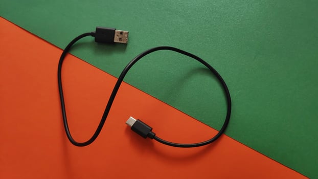 white voltage charger with usb cable for phone and gadgets charge on colored and lighting background photo