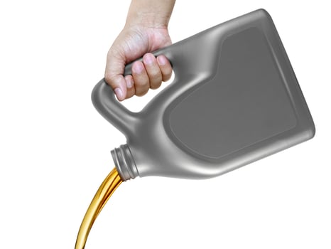 Engine oil pouring from a canister in hand isolated on white background photo