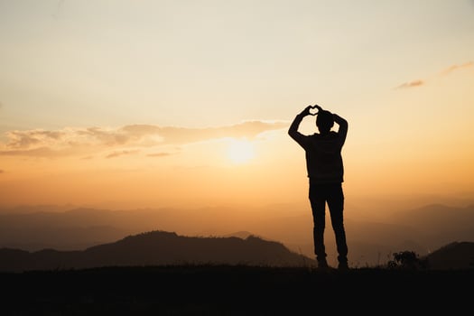 Woman making heart shape during sun rise, God is love concept, Heart shape, Mountain tourism,  The manifestation of love,  Love and feelings. photo