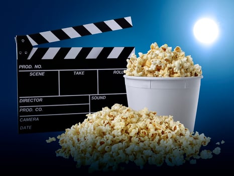 watching movie with popcorn on blue background photo
