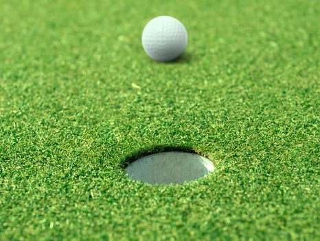 golf ball on lip of cup of lovely beautiful golf course photo
