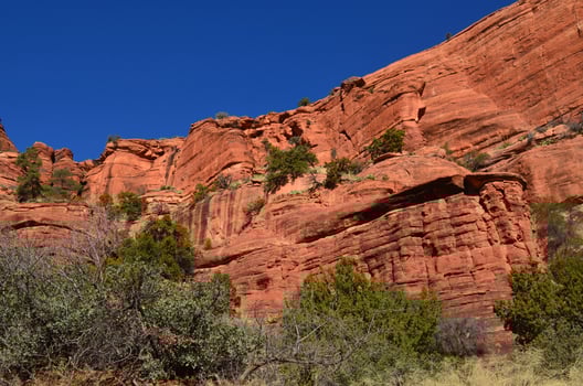 Vibrant Blue Skies Over a Stunning Rock Wall photo