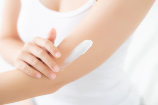 Closeup beautiful young asian woman smile applying sunscreen cream lotion on skin care at bedroom, beauty asia girl makeup and cosmetic for smooth and silky, wellness and health concept. photo