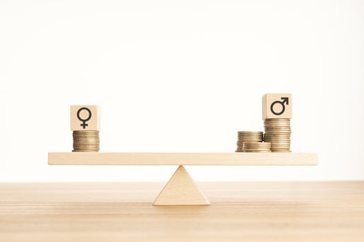 Wage gap between men and women concept. Wooden block with gender symbol on stacked coins on a seesaw. Copy space photo