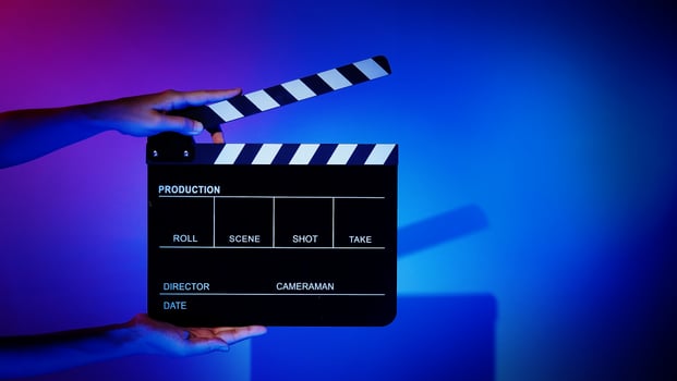 Crew hand holding plastic and wooden film slate board against camera. photo