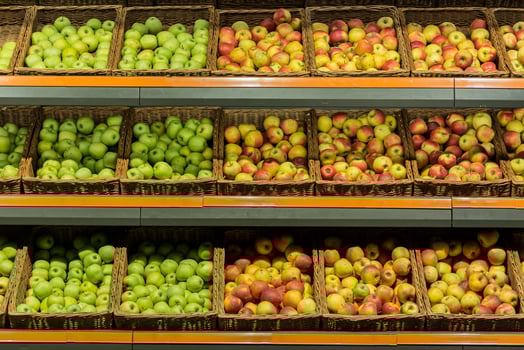 Shelves boxes with fruit colorful apples in the supermarket store on the counter photo