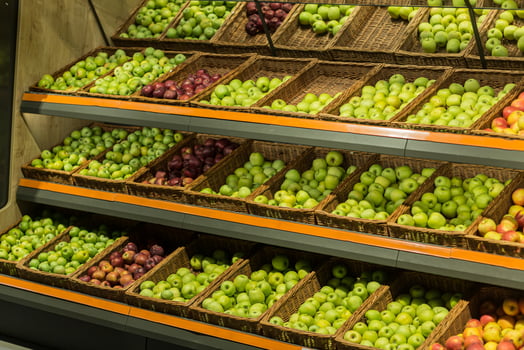 Shelves boxes with fruit colorful apples in the supermarket store on the counter photo