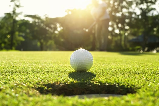 golf player putting golf ball into hole photo