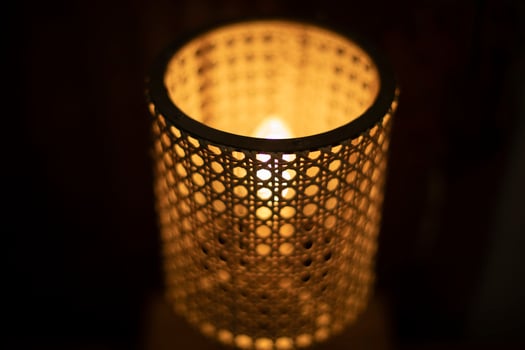 Lamp in dark. Wooden lampshade around incandescent lamp. photo