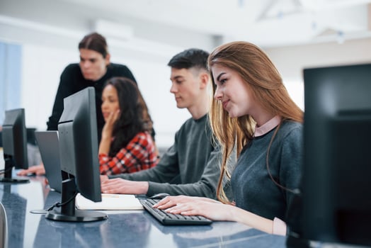 Computer screens. Group of young people in casual clothes working in the modern office photo