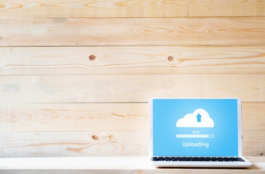 Cloud uploading on laptop  on wood table photo