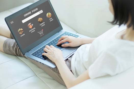 Close up woman sitting and orde food online on laptop computer photo