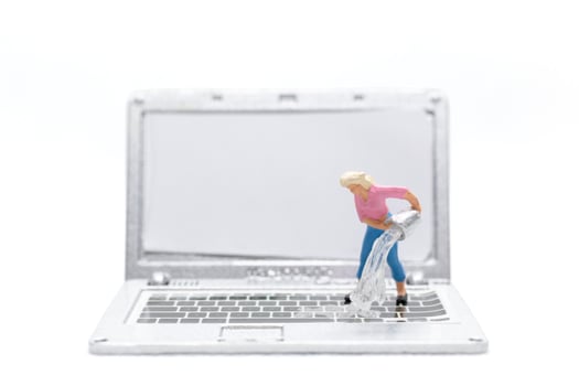 Miniature people cleaning laptop computer on white background photo