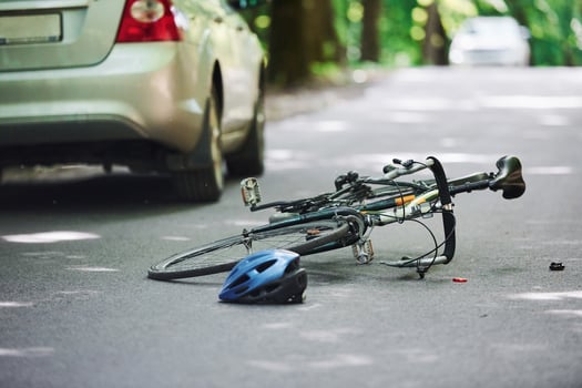 Bicycle and silver colored car accident on the road at forest at daytime photo